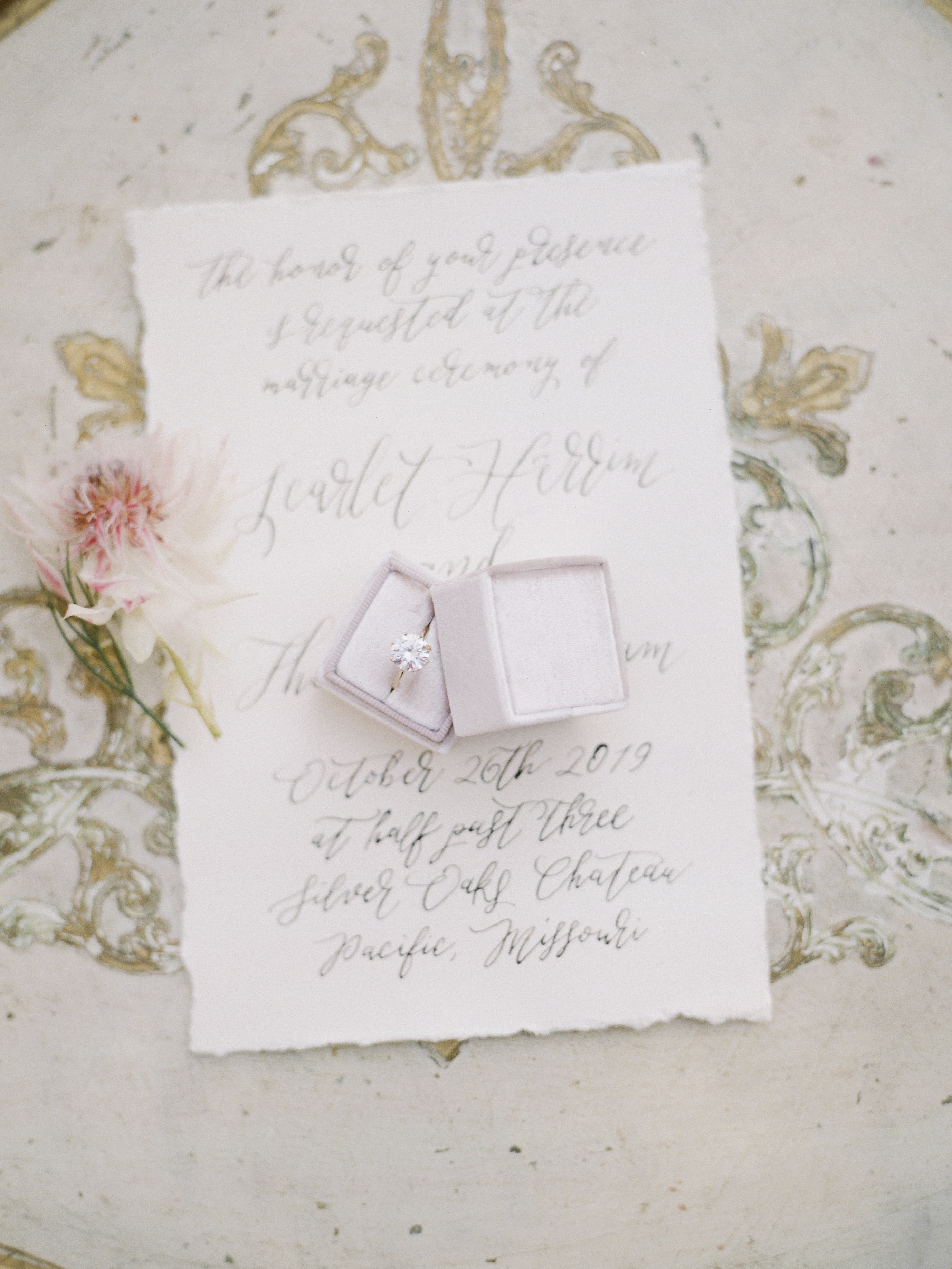 Gold solitaire engaement ring in a basket of diamonds by Lauren Priori Jewelery on handwritten wedding invitation by The Ink Cafe photographed by fine art wedding photographer Love Tree Studios in St. Louis Missouri.
