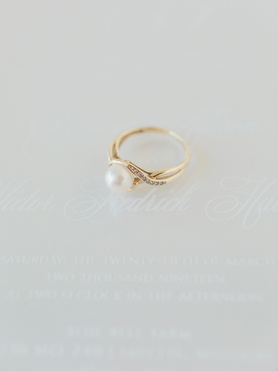 A detail photograph of the bride's ring on her invitaion by The Ink Cafe from Missouri wedding photographer Love Tree Studios.