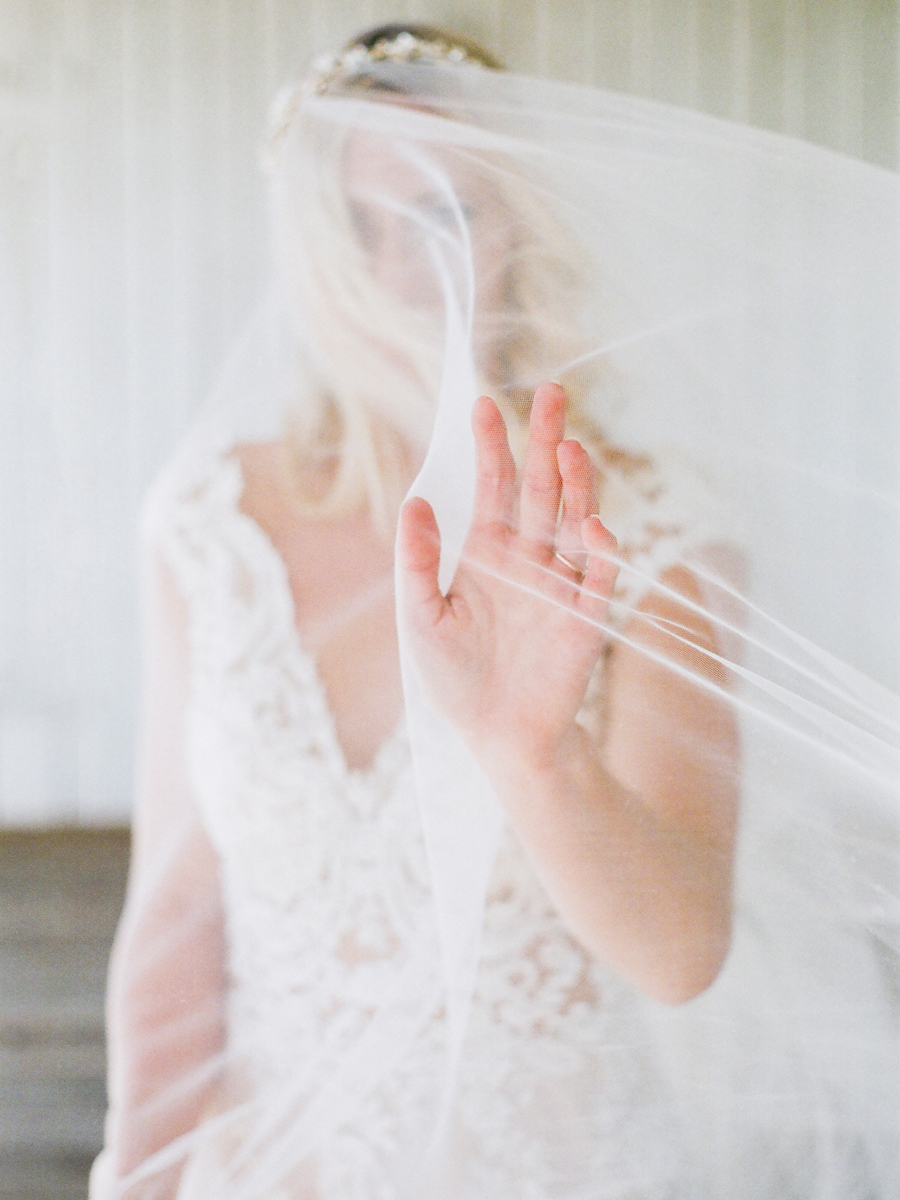 The bride reached through her veil at Missouri wedding venue Blue Bell Farm captured by Love Tree Studios.
