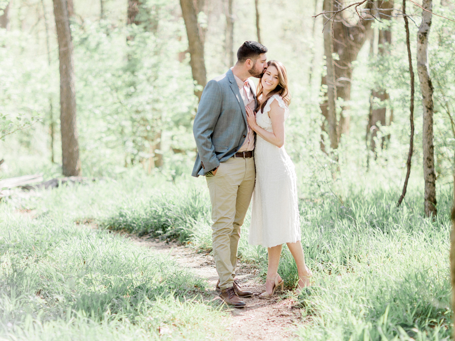 A couple kisses during their woodland engagement session in Capen Park by wedding photographer Love Tree Studios in Columbia, Missouri.