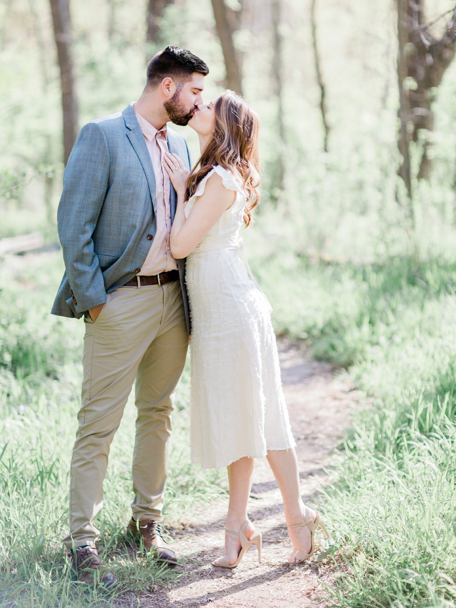 A couple kisses during their woodland engagement session in Capen Park by wedding photographer Love Tree Studios in Columbia, Missouri.