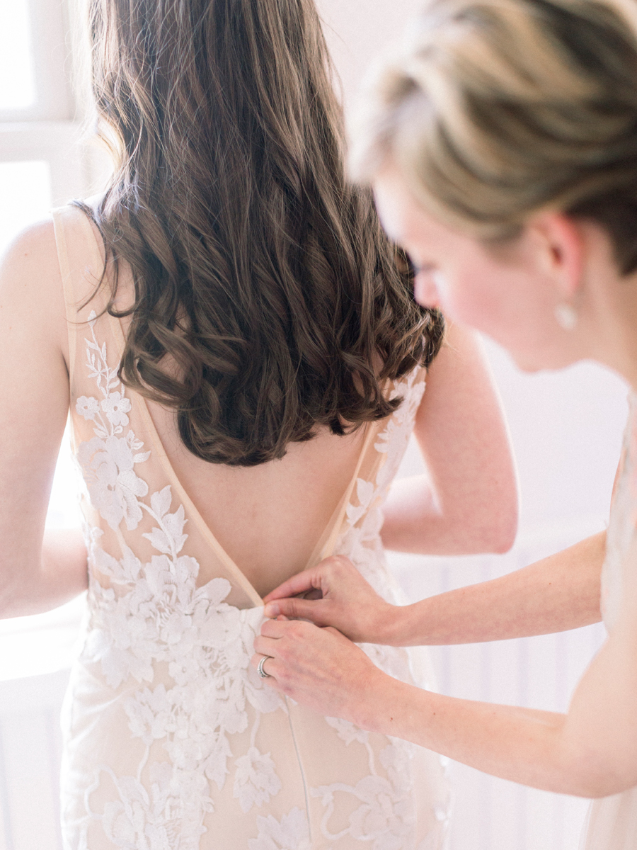 The bride puts on her wedding dress for her Columbia Missouri wedding photographed by Love Tree Studios.