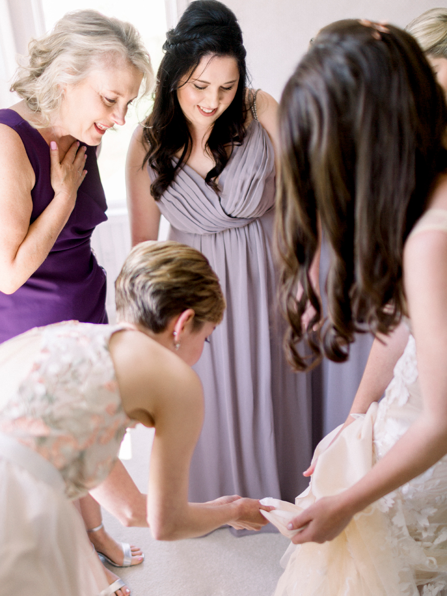 The bride puts on her wedding dress for her Columbia Missouri wedding photographed by Love Tree Studios.