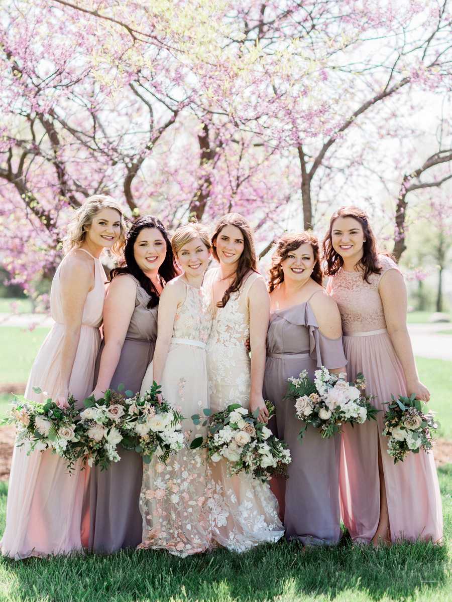 The bride and her bridesmaids pose for a portrait at a Columbia Missouri wedding by photographer Love Tree Studios.