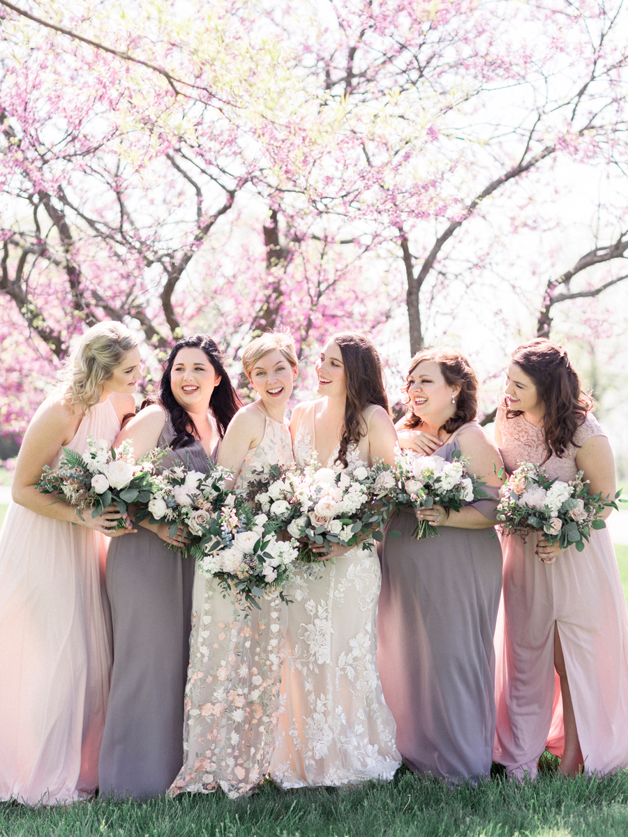 The bride and her bridesmaids pose for a portrait at a Columbia Missouri wedding by photographer Love Tree Studios.