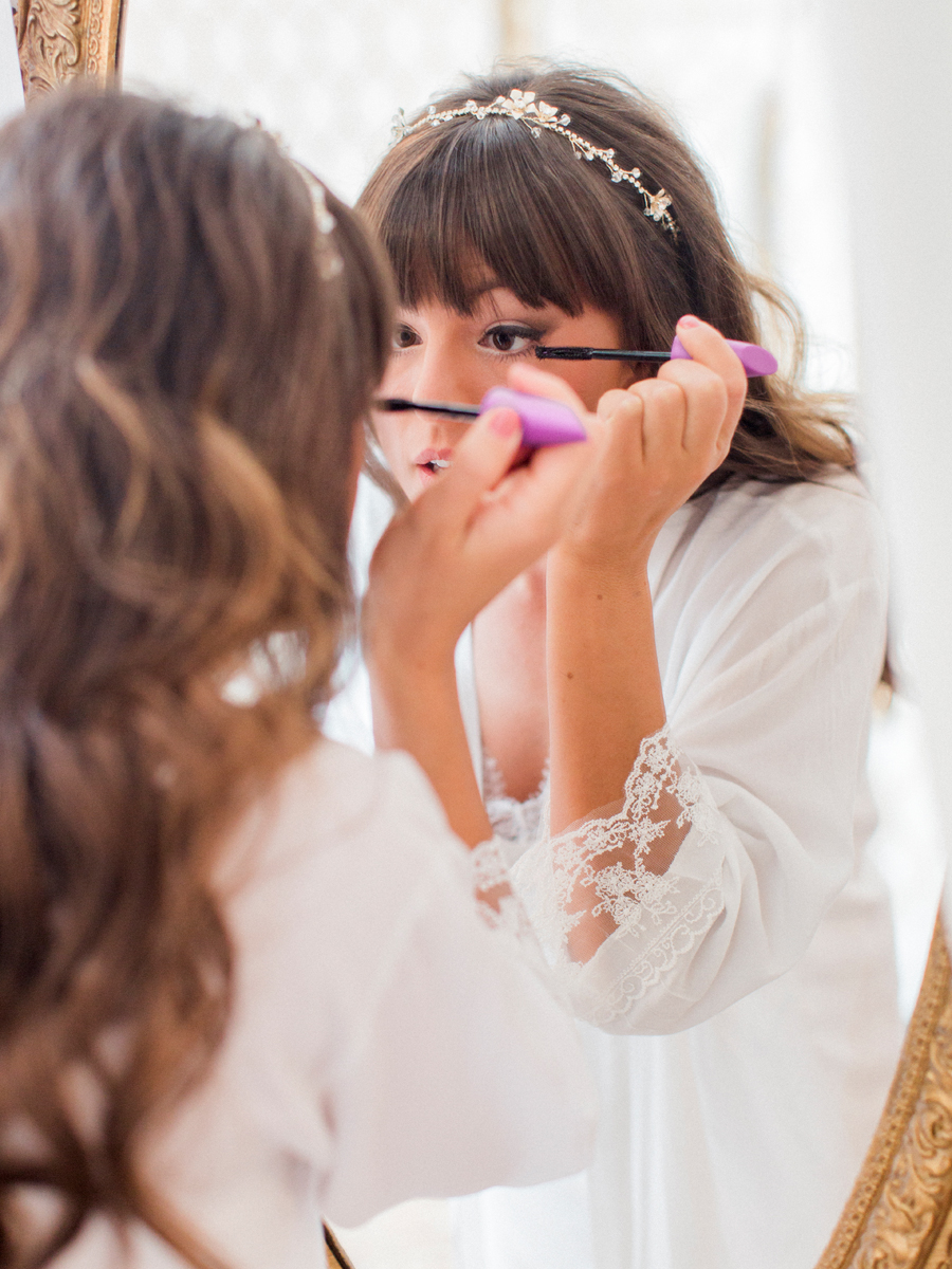 A bride applies finishing touches on her wedding day at The Exchange Venue at her Camdenton Missouri wedding photographed by Love Tree Studios.