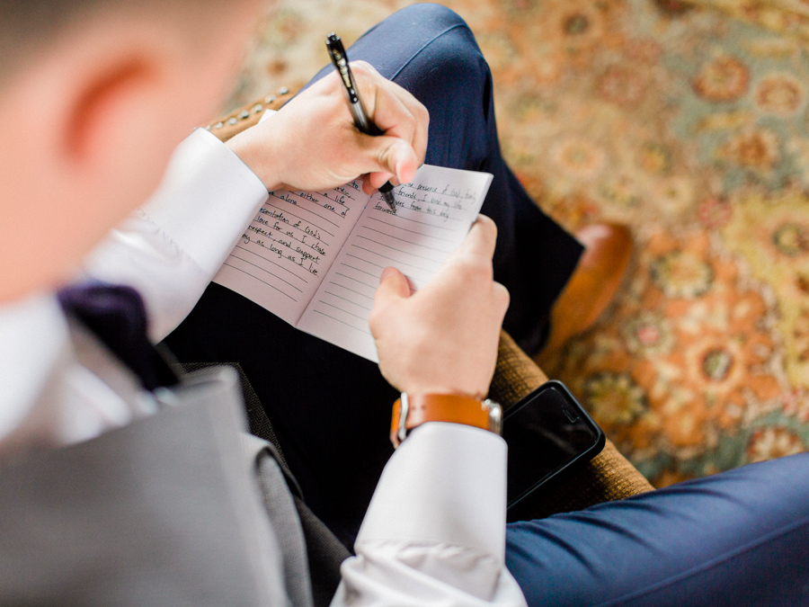 The groom writes his vows before the ceremony photographed by Love Tree Studios at his Camdenton Missouri wedding.