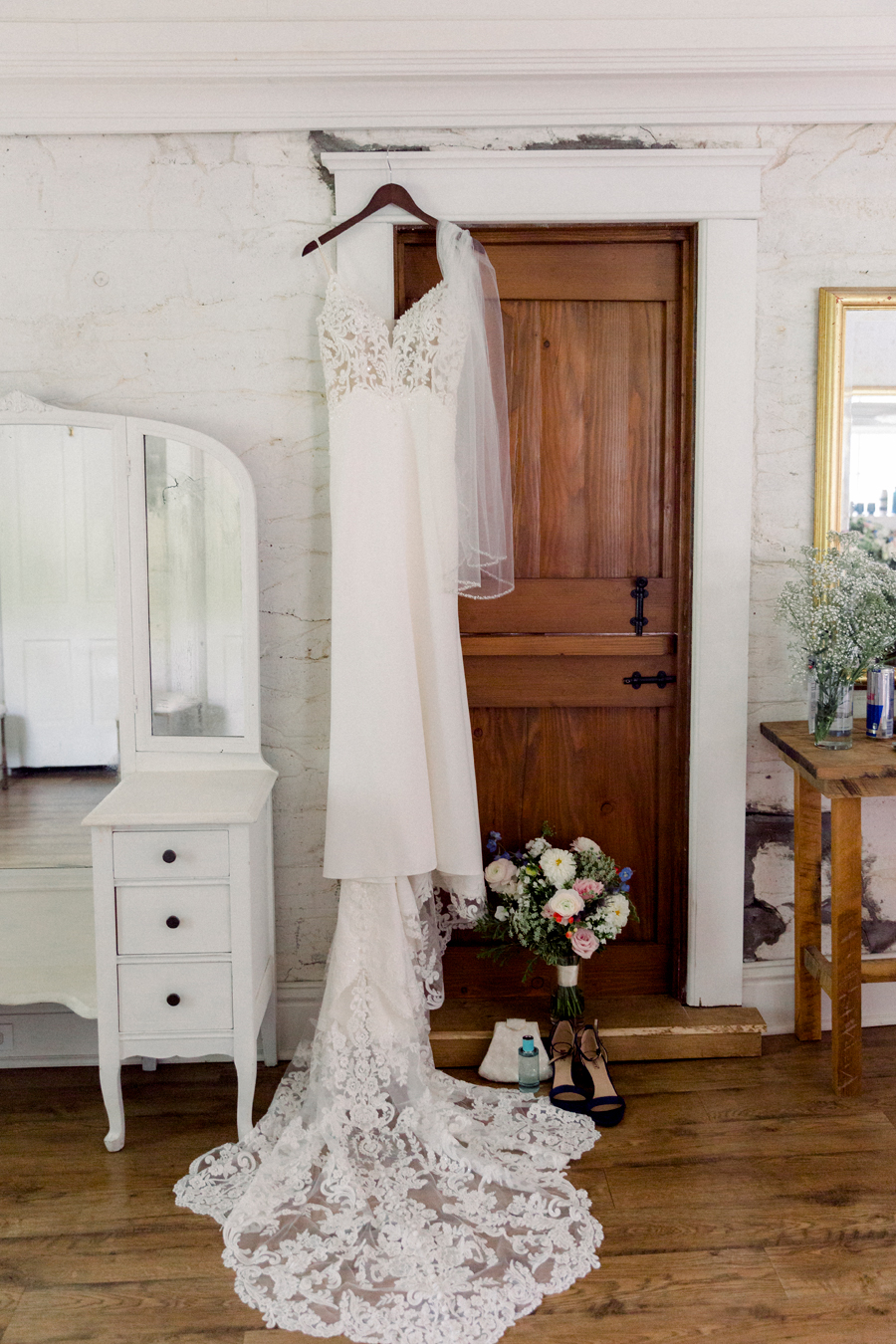 The bride's dress hangs on the doorframe in the cottage at Wildcliff Weddings and Events.