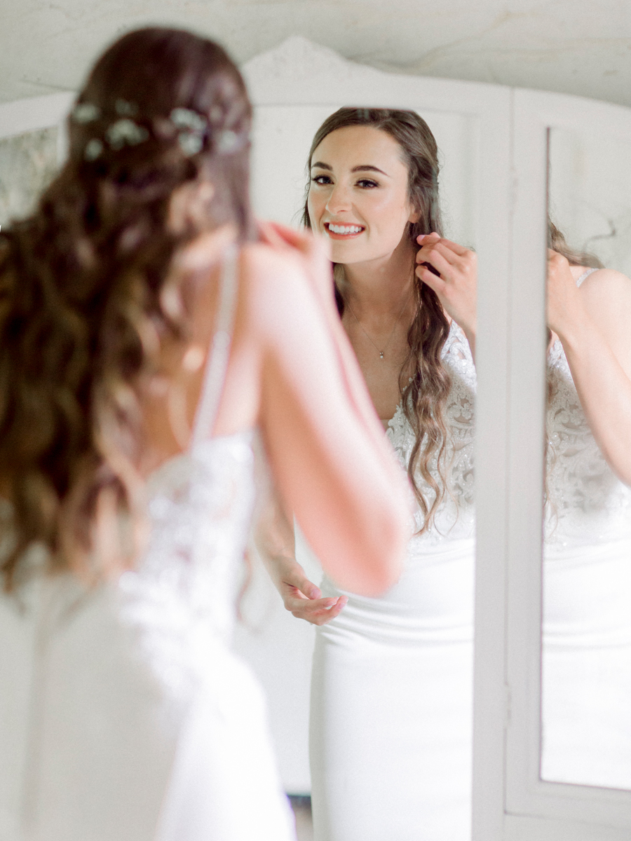 The bride looks in the mirror in the bridal cottage at Wildcliff Weddings and Events.