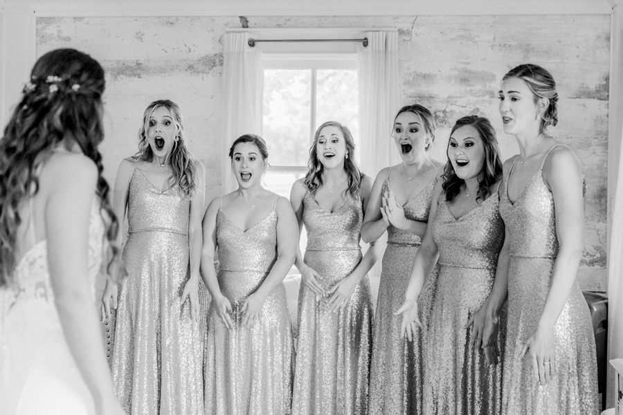 A bride does a first look with her bridesmaids at Wildcliff Weddings and Events.