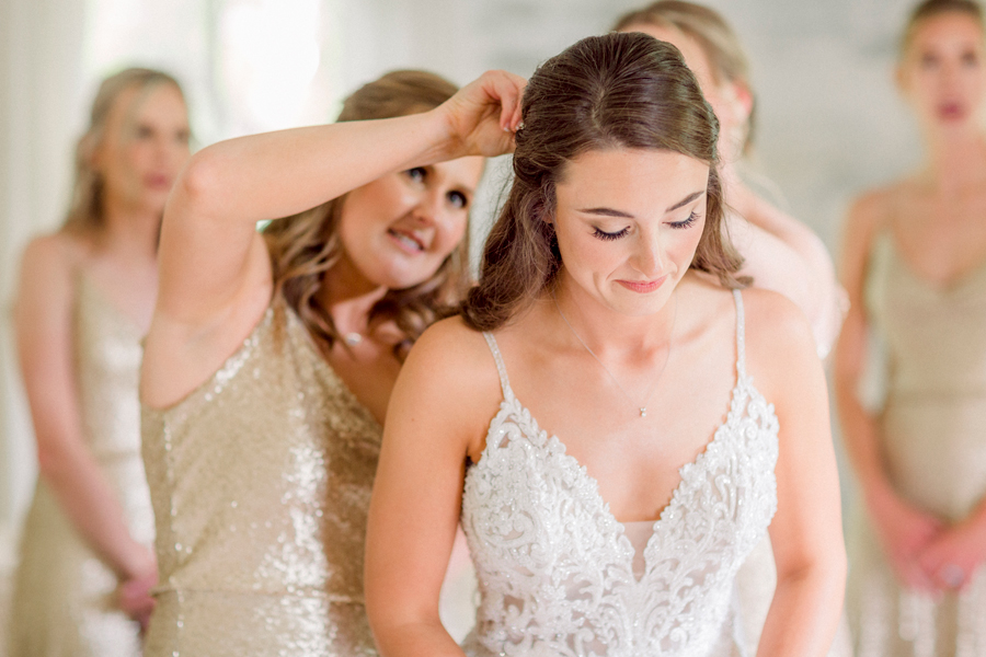 A bridesmaid puts in the bride's veil for her wedding in Blackwater, Missouri.