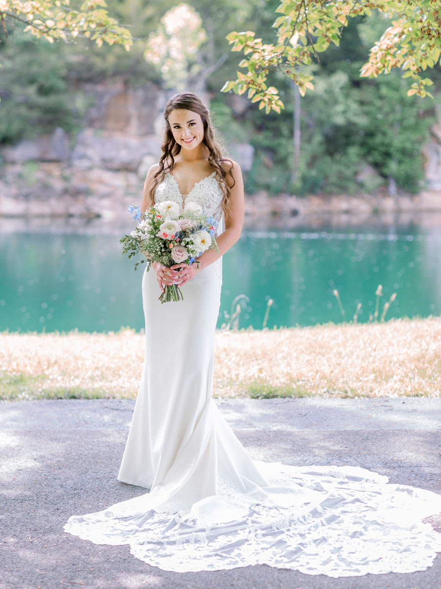 A bride poses in front of the water and cliffs at Wildcliff Weddings and Events.