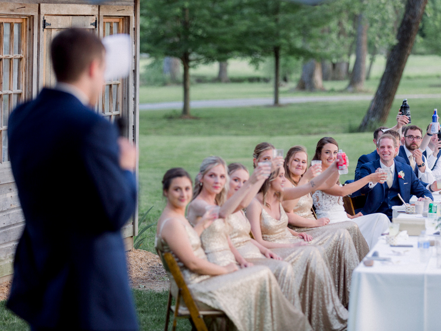 Guests looks on as toasts are given during an outdoor Missouri wedding at Wildcliff Weddings and Events.