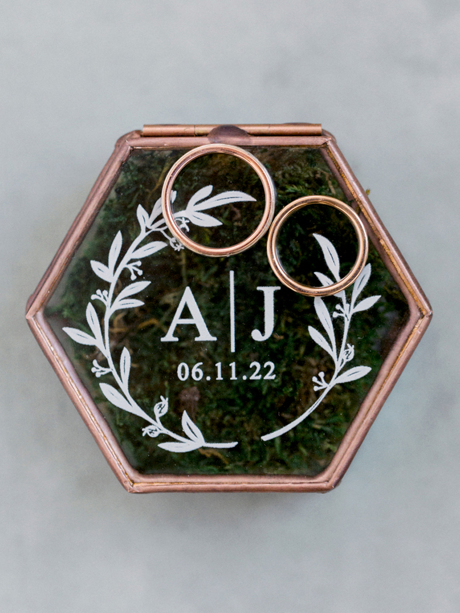 A glass ring box with the couple's initials engraved at a Blue Bell Farm wedding by Love Tree Studios.