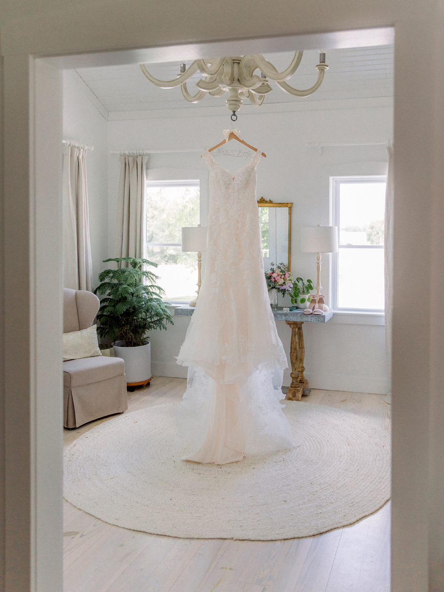 The bride's wedding gown hangs in the bridal suite at a Blue Bell Farm wedding by Love Tree Studios.