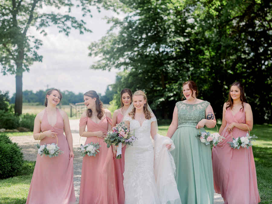 The bridal party walks down the gravel road at a Blue Bell Farm wedding by Love Tree Studios.