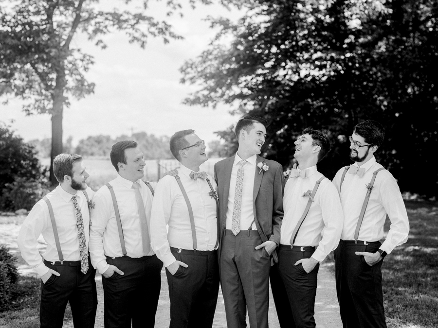 A groom laughs with his groomsmen at a Blue Bell Farm wedding by Love Tree Studios.