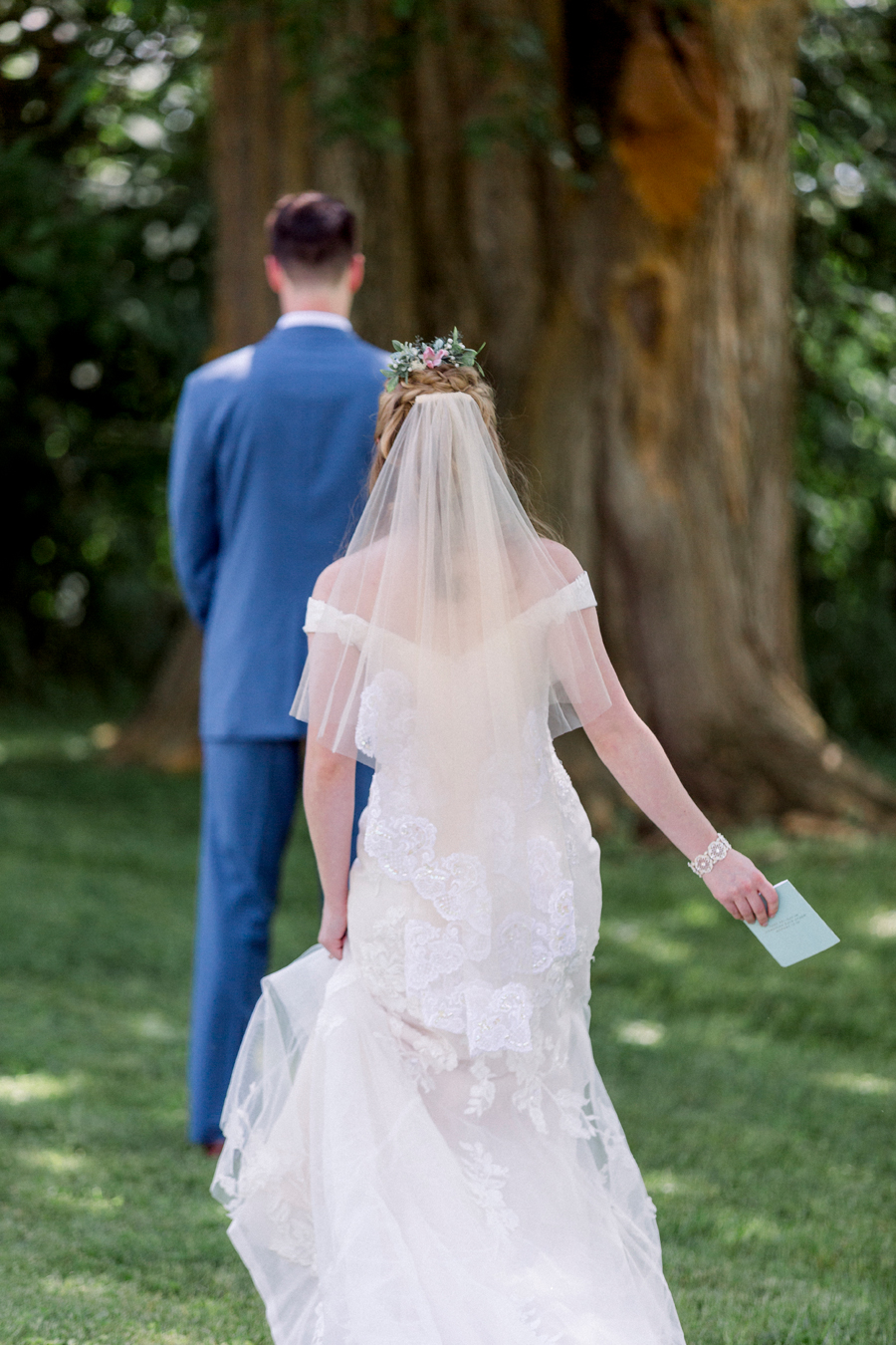The bride sneaks up behind the groom during the first look at a Blue Bell Farm wedding by Love Tree Studios.