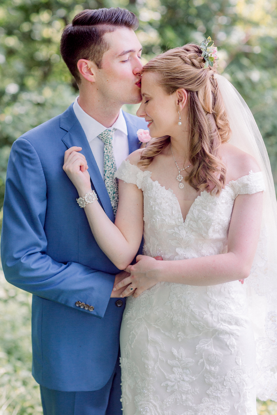 The groom kisses the bride's forehead at a Blue Bell Farm wedding by Love Tree Studios.