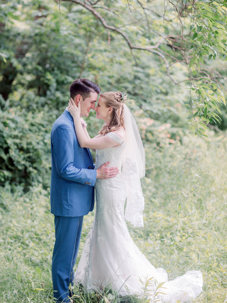 The bride and groom share a loving embrace at a Blue Bell Farm wedding by Love Tree Studios.