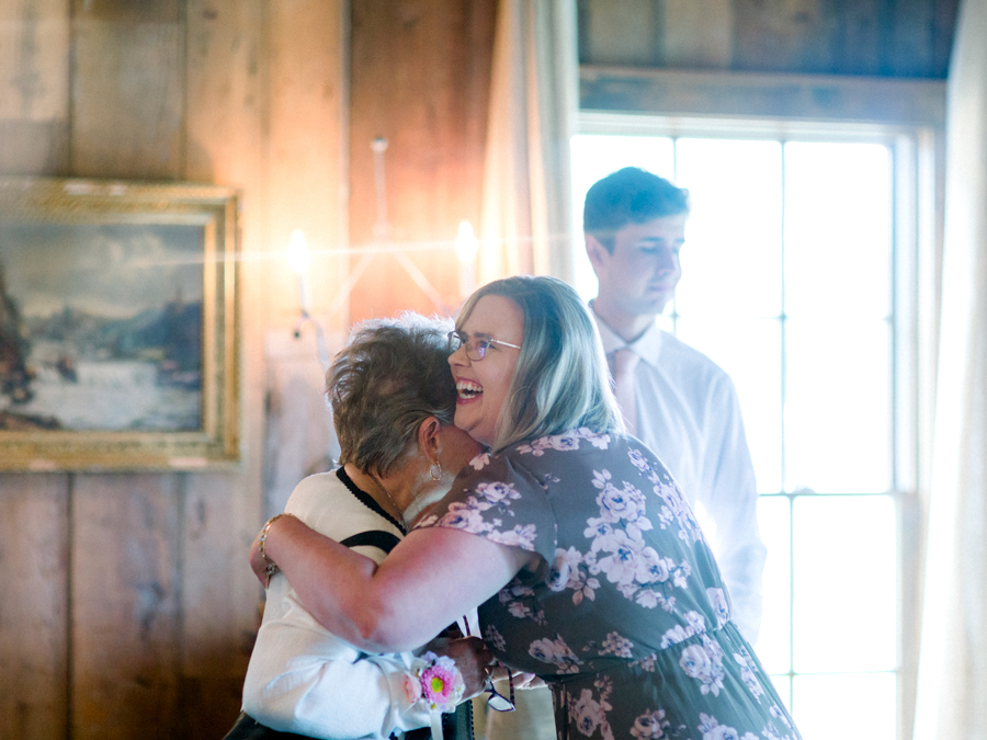 Guests hug at a Blue Bell Farm wedding by Love Tree Studios.