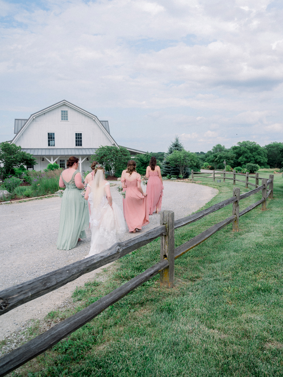 The bridal party walks toward the barn at a Blue Bell Farm wedding by Love Tree Studios.
