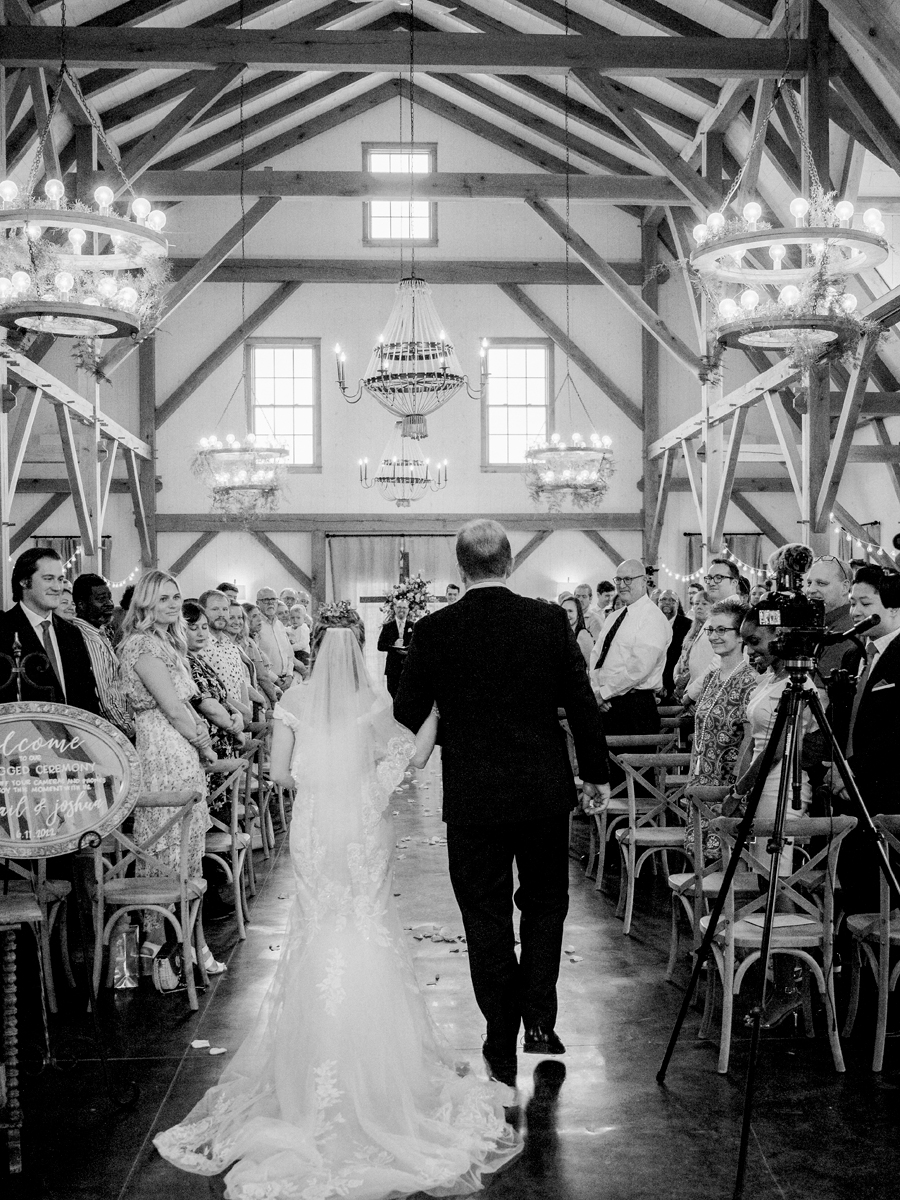 The bride walks down the aisle with her father at a Blue Bell Farm wedding by Love Tree Studios.