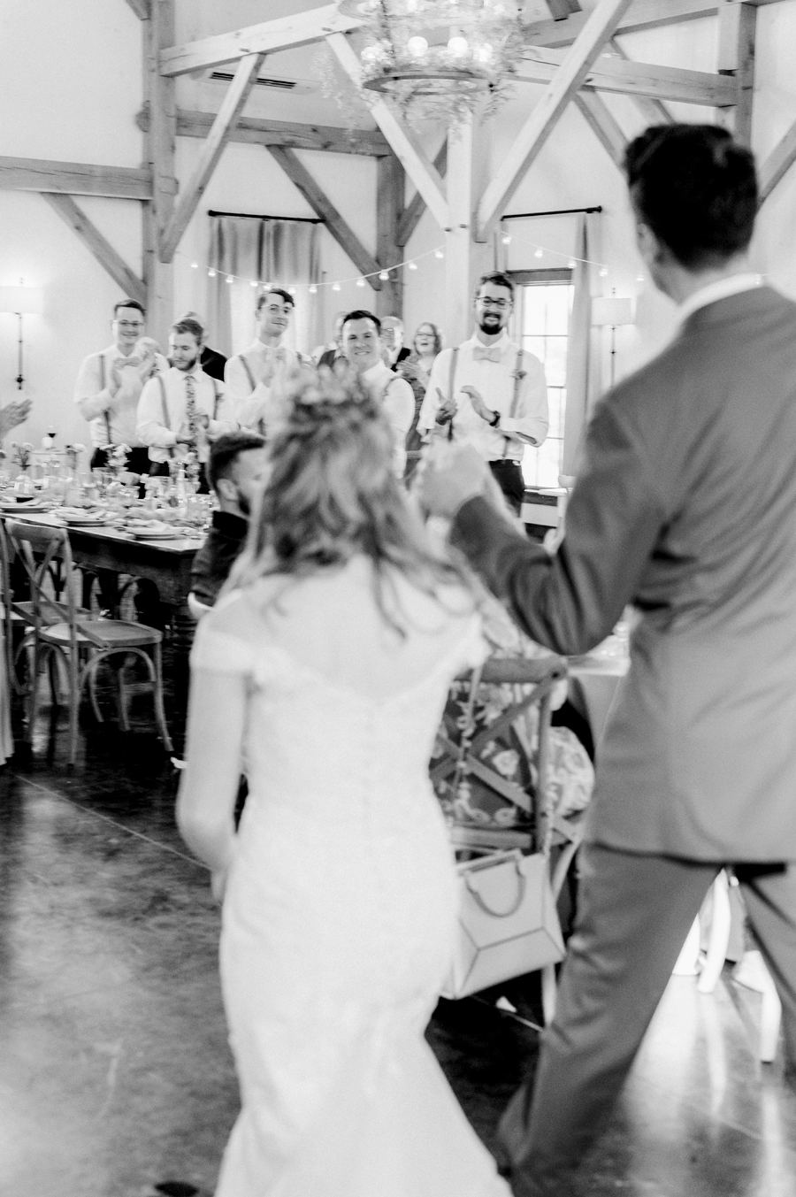 Guests cheer as the bride and groom enter the reception at a Blue Bell Farm wedding by Love Tree Studios.