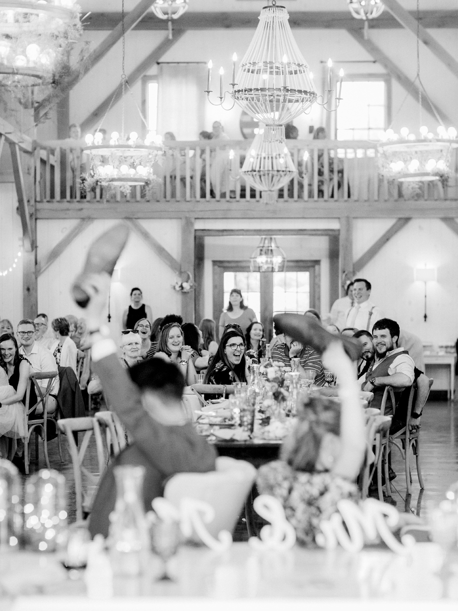 Guests laugh at the bride and groom during the shoe game at a Blue Bell Farm wedding by Love Tree Studios.