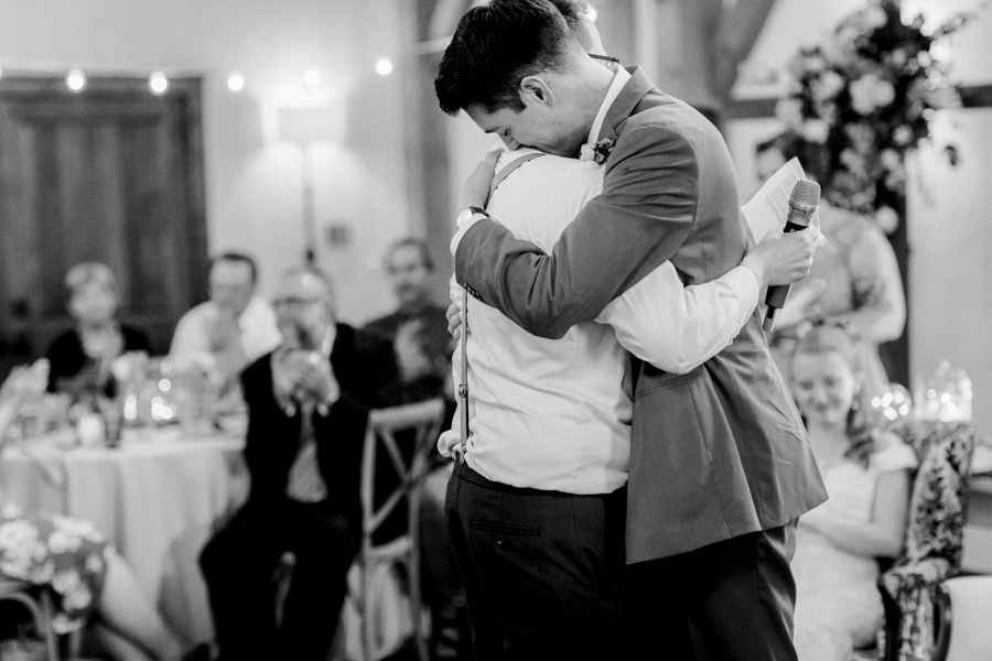 The groom hugs the best man at a Blue Bell Farm wedding by Love Tree Studios.