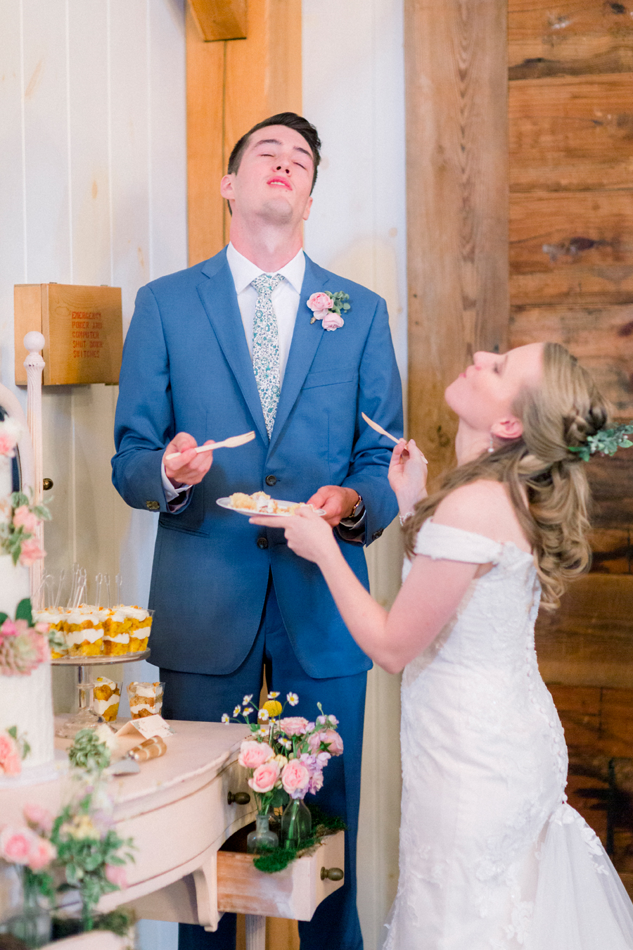 The bride and groom taste the cake at a Blue Bell Farm wedding by Love Tree Studios.