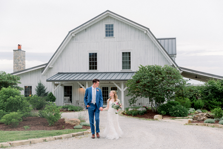 A bride and groom walk in front of barn at a Blue Bell Farm wedding by Love Tree Studios.