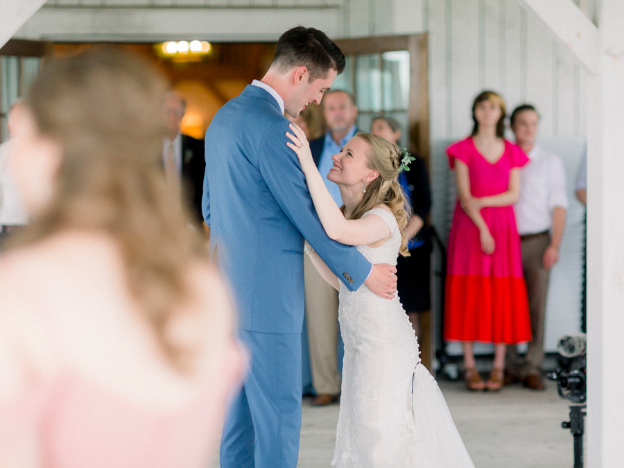 The bride smiles at the groom during the first dance at a Blue Bell Farm wedding by Love Tree Studios.