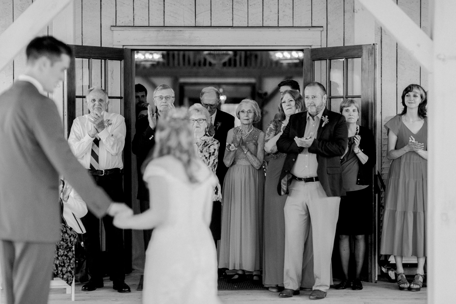 Guests clap as the bride and groom have their first dance at a Blue Bell Farm wedding by Love Tree Studios.