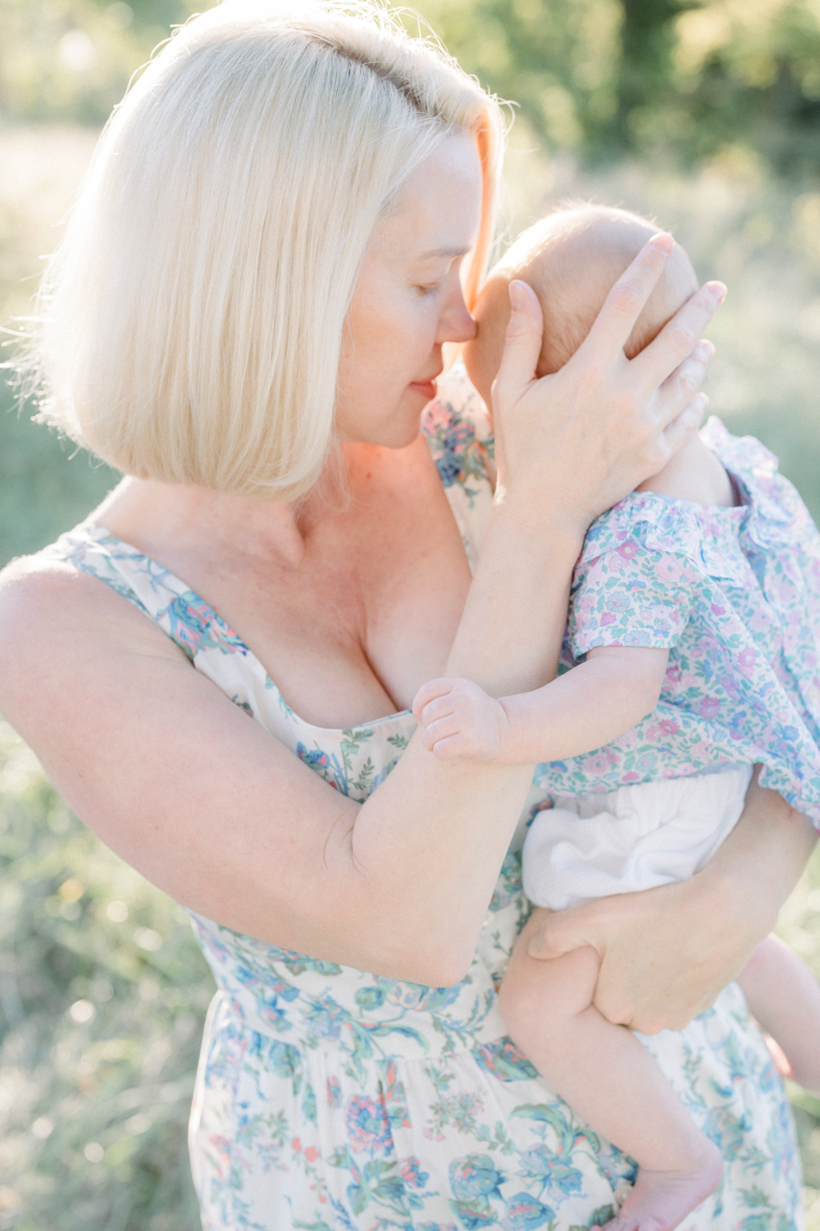 A mom snuggles with her baby during their Fayette Missouri family photography session by Love Tree Studios.