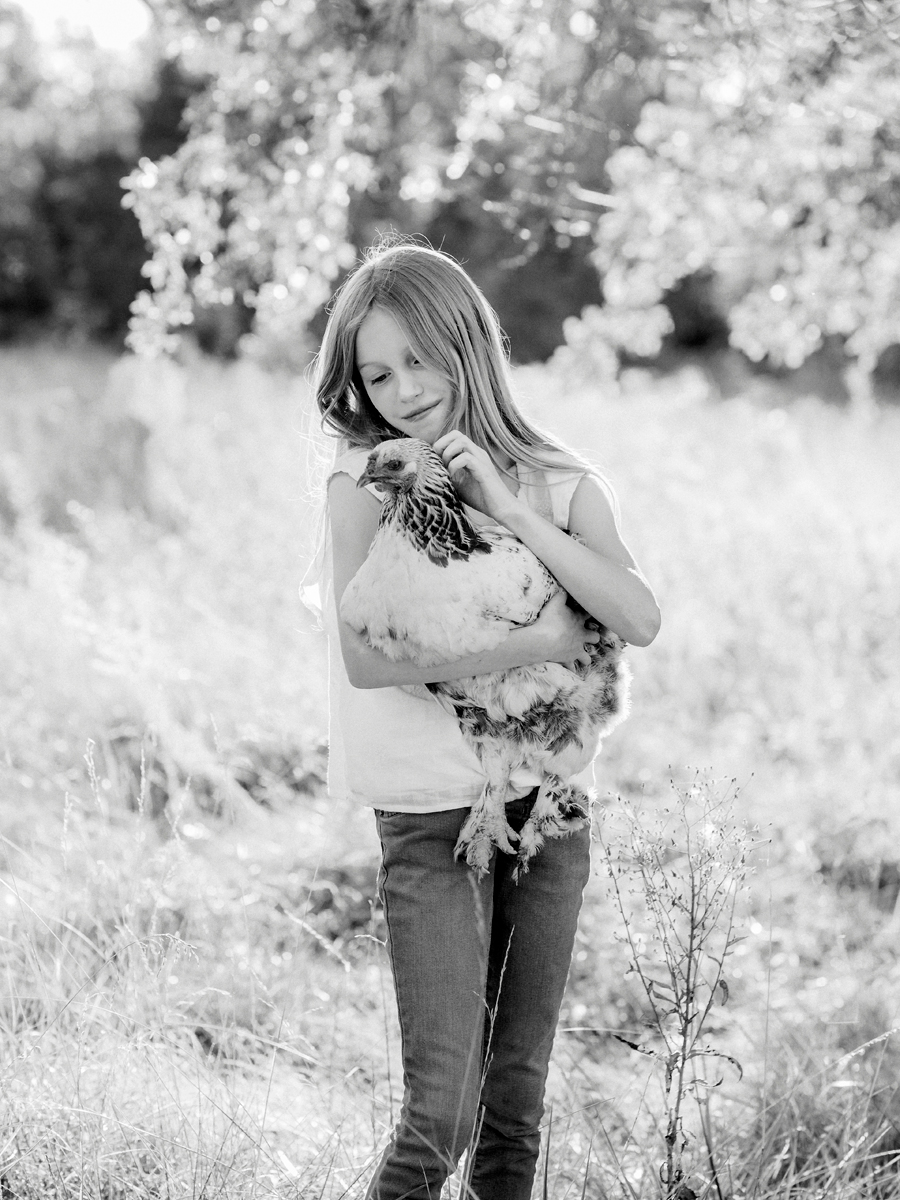 A girl poses with her chicken during her Fayette Missouri family photography session.