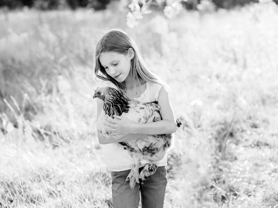 A girl poses with her chicken during her Fayette Missouri family photography session.