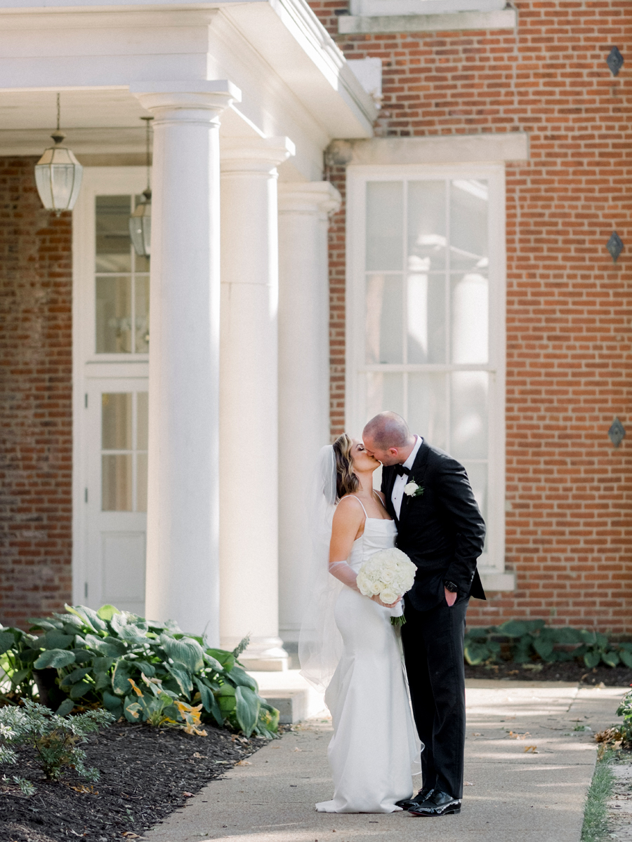 A bride and groom take portraits in front of Senior Hall for their Stephens College wedding photographed by Missouri wedding photographer Love Tree Studios.