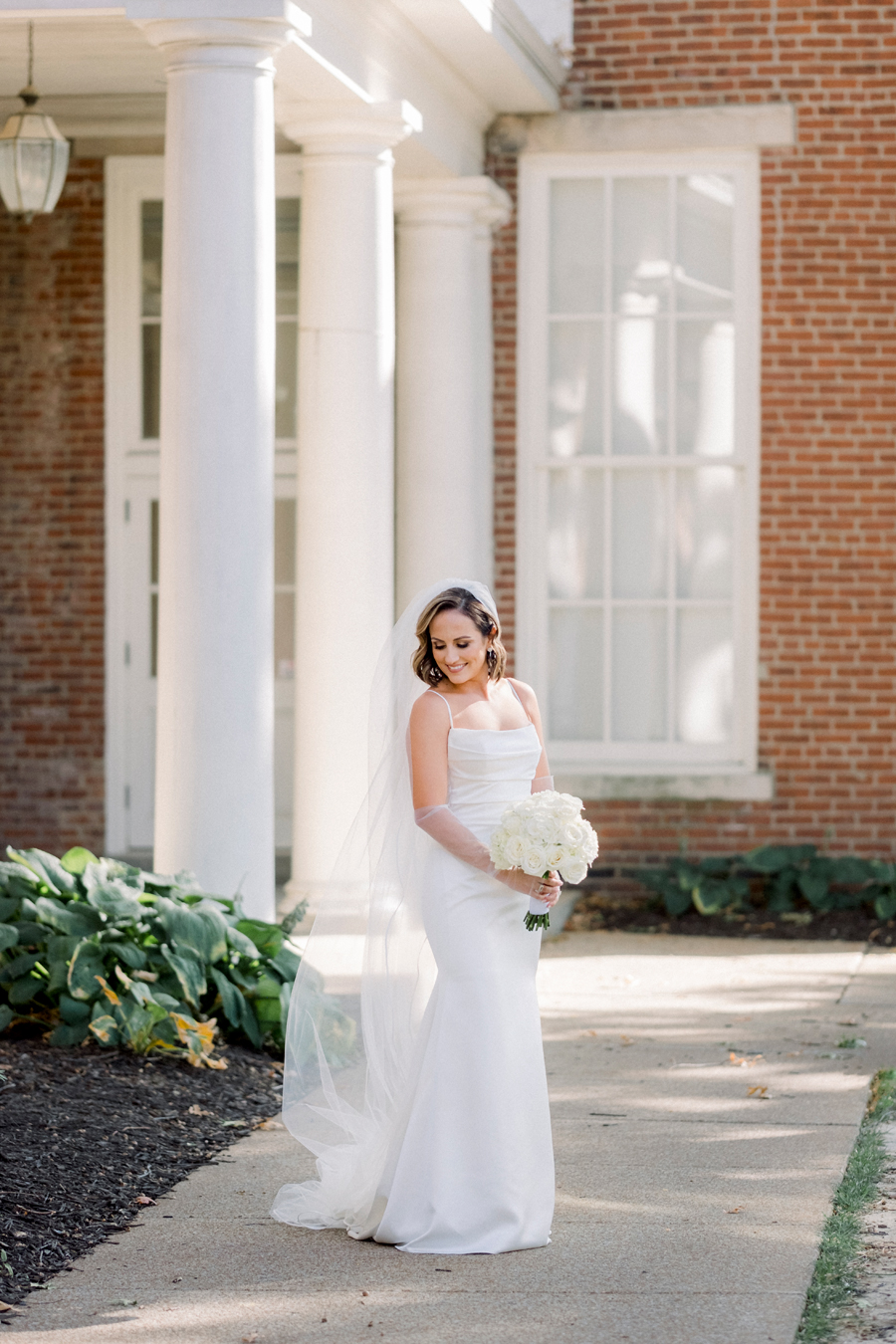 A bride and groom take portraits in front of Senior Hall for their Stephens College wedding photographed by Missouri wedding photographer Love Tree Studios.