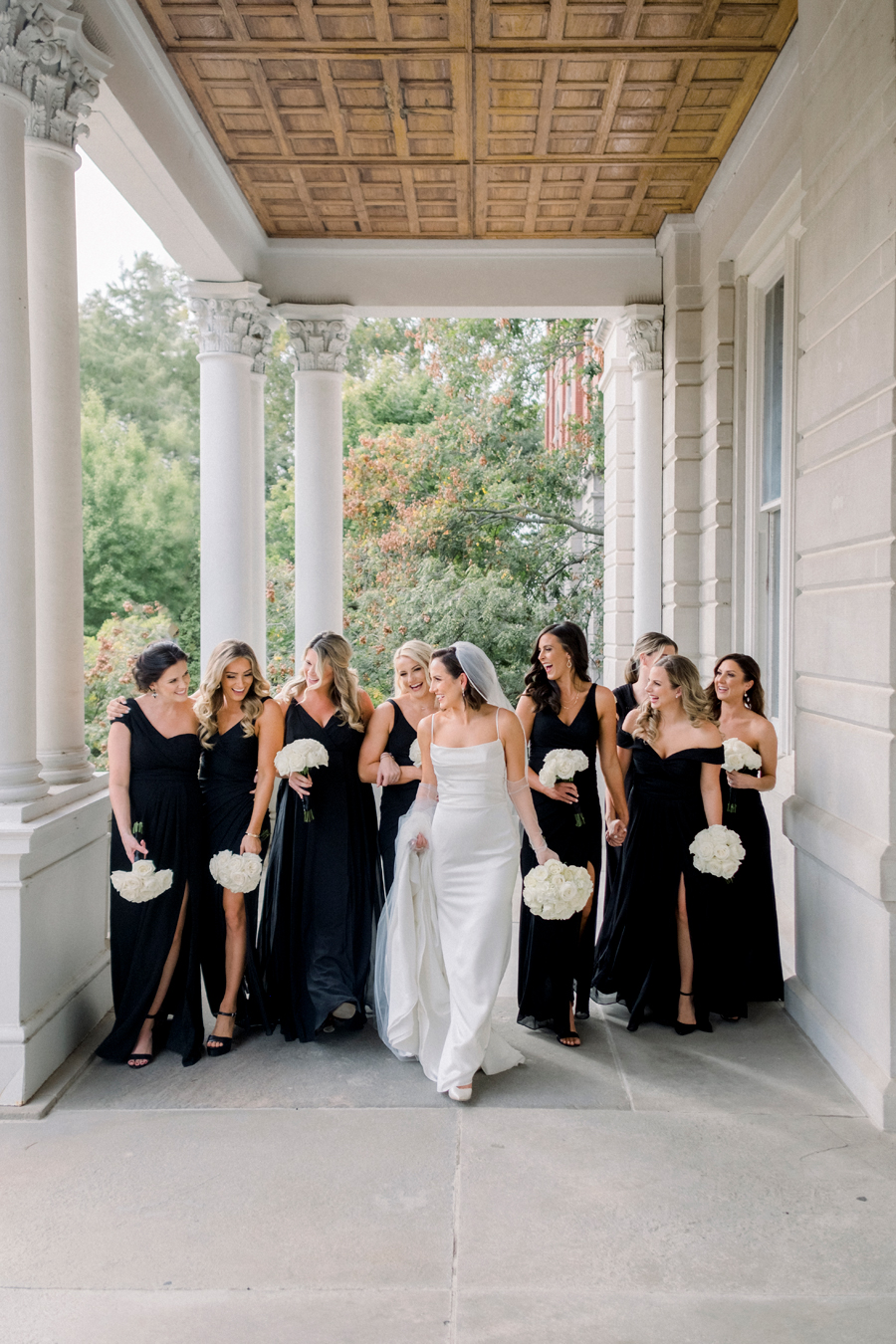 A bride poses with her bridesmaids on the University of Missouri's campus for her Stephens College wedding photographed by Columbia, Missouri wedding photographer Love Tree Studios.