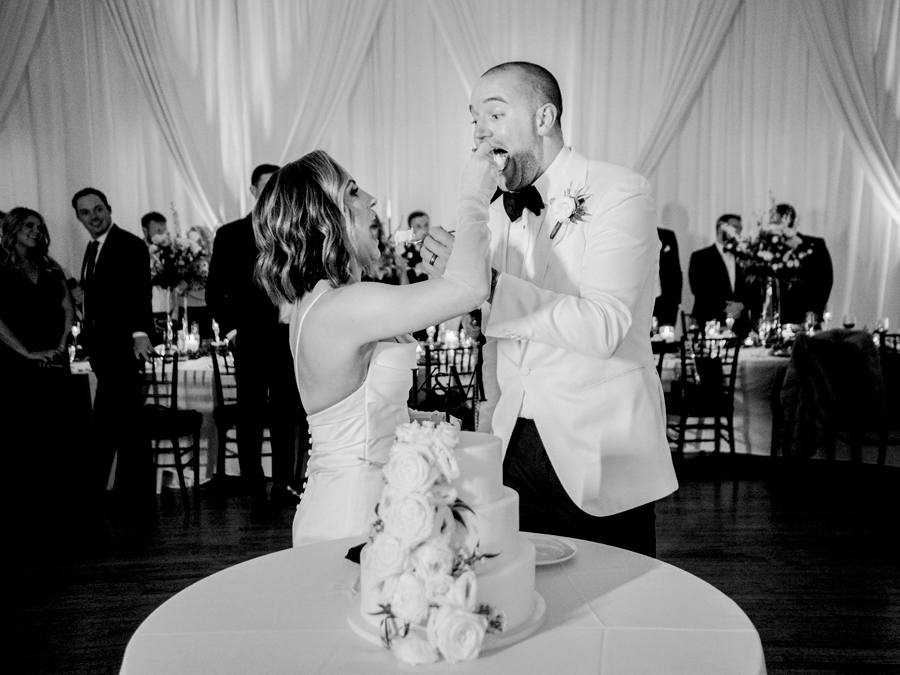 The bride and groom cut the cake at their wedding reception in Kimball Ballroom for their Stephens College wedding photographed by Columbia, Missouri wedding photographer Love Tree Studios.
