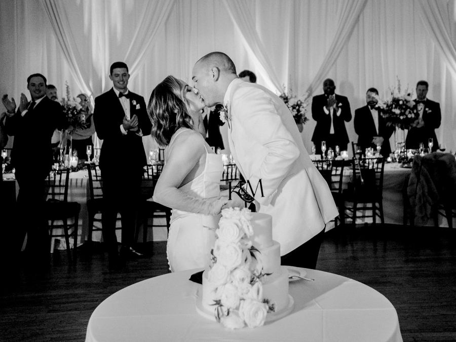 The bride and groom cut the cake at their wedding reception in Kimball Ballroom for their Stephens College wedding photographed by Columbia, Missouri wedding photographer Love Tree Studios.