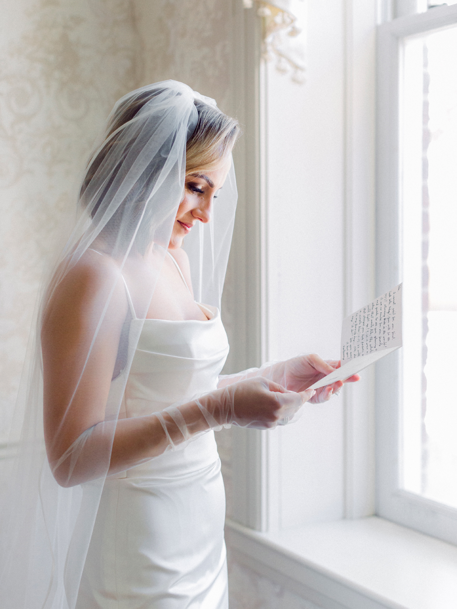 A bride reads a letter from the groom before her Stephens College wedding photographed by St. Louis, Missouri wedding photographer Love Tree Studios.