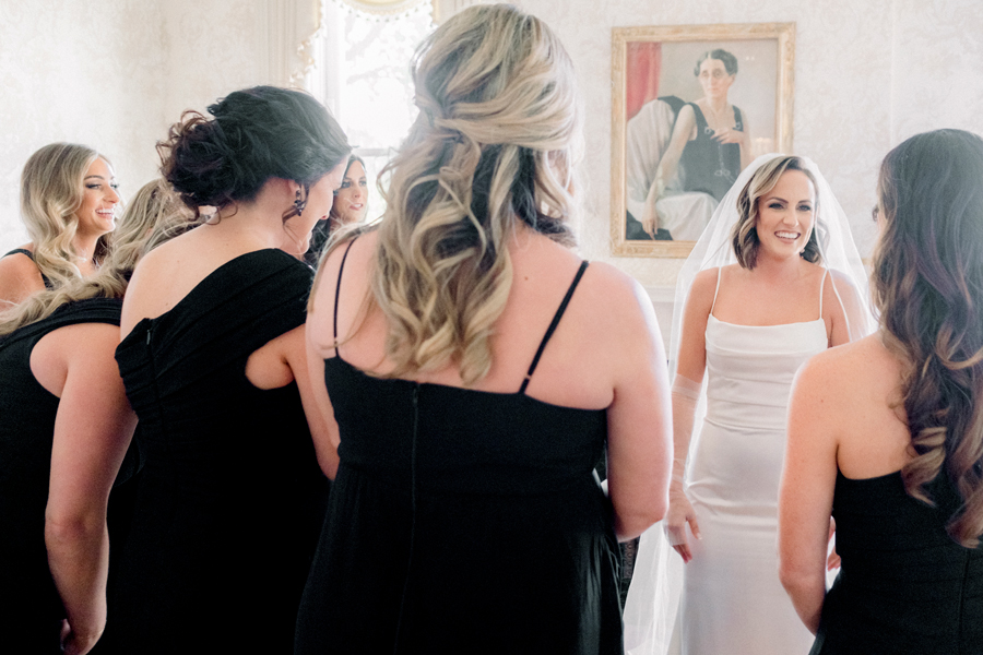 A bride does a first look with her bridesmaids before her Stephens College wedding photographed by Jefferson City, Missouri wedding photographer Love Tree Studios.