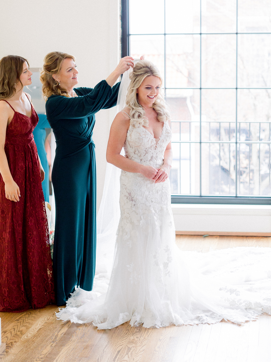 The bride puts on her wedding dress for her Atrium on Tenth wedding in Columbia, Missouri by Love Tree Studios.