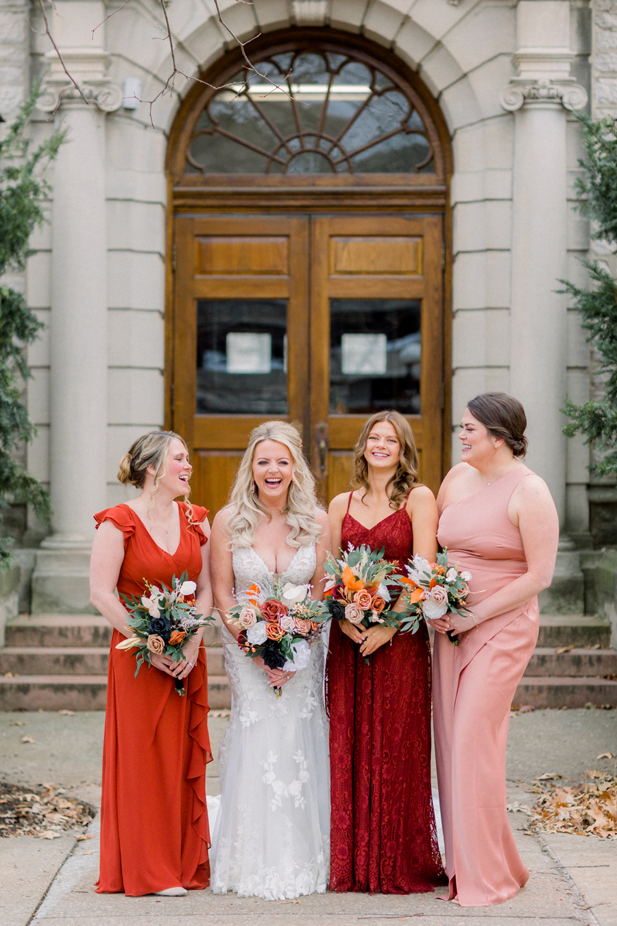 The bride and bridesmaids laugh during portraits on Mizzou campus before their Atrium on Tenth wedding in Columbia, Missouri by Love Tree Studios.