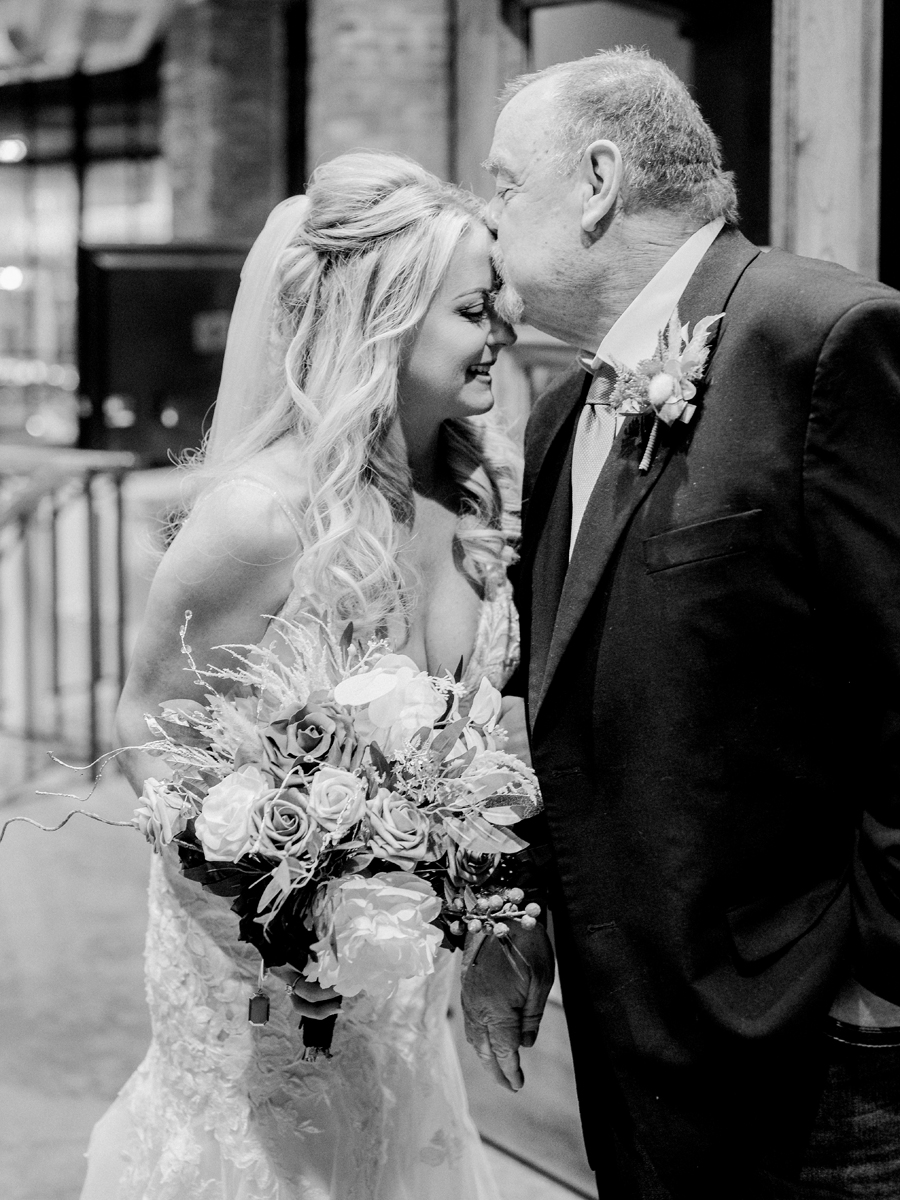 A bride laughs with her father before walking down the aisle at her wedding at Atrium on Tenth wedding in Columbia, Missouri by Love Tree Studios.