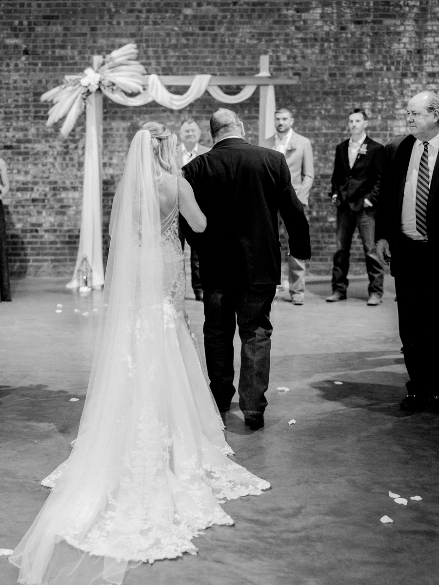 A bride walks down the aisle at her wedding at Atrium on Tenth wedding in Columbia, Missouri by Love Tree Studios.