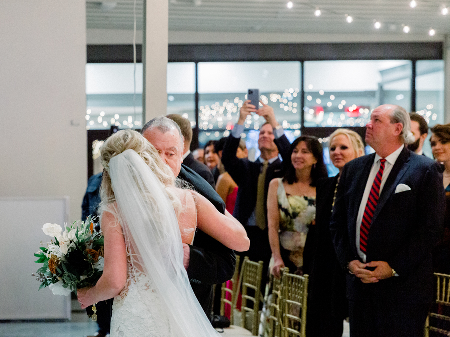 A bride walks down the aisle at her wedding at Atrium on Tenth wedding in Columbia, Missouri by Love Tree Studios.