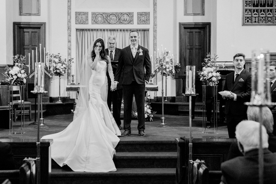 The bride and groom get married at First Christian Church before their The Atrium on Tenth wedding in Columbia, Missouri by Love Tree Studios.